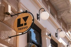 a sign hanging on the side of a building at Living Yard Thissio in Athens