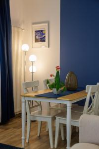 mesa de comedor con sillas blancas y pared azul en RESIDENCE PARCO TALENTI, en Roma