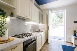Una cocina con gabinetes blancos y un horno de estufa. en RESIDENCE PARCO TALENTI, en Roma