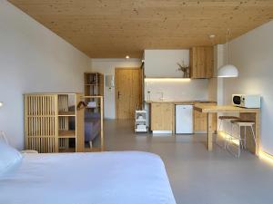 a bedroom with a bed and a desk and a kitchen at Maison Laida in Ibarrangelu