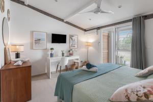 a bedroom with a bed and a desk with a computer at Sweet Home sur la plage in Marigot