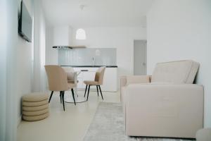 a white living room with a white couch and chairs at Guest House Barrelas in Vila Nova de Paiva