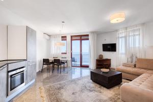 a living room with a couch and a table at Blue Seacliff Luxe in Komoševina