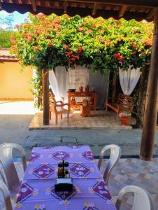 a table and chairs with flowers on a patio at pousada recanto do coelho in Roseira