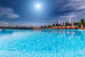 a large swimming pool with chairs and umbrellas at Villa Elena SPA & Resort in Bukovel +108 photos