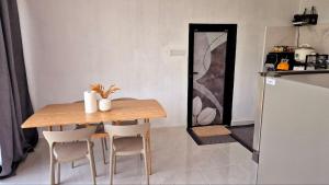 a wooden table and chairs in a kitchen with a refrigerator at Villa Aisya in Kampung Padang Masirat