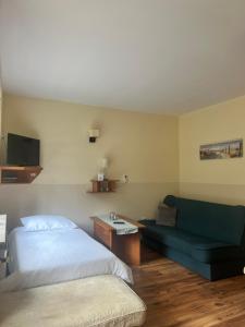 a hotel room with a bed and a couch at Barnaba Domki in Pobierowo