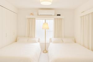 Cama ou camas em um quarto em 편의점까지10초걸리는아늑한아파트 신주쿠2분 역5분 16평 최대4명 부엌침실 장기체류환영