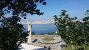 a cross on a stone wall with a view of a lake at Jasmina in Senj