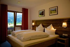 a bedroom with a large bed with a large window at Gästehaus Weller in Oberstdorf