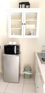 a kitchen with a microwave and a refrigerator at The Hibiscus Retreat in Arima