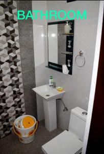 Un baño con lavabo, inodoro y espejo. en Homestay S 4, en Amritsar