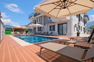 una villa con piscina y sombrilla en Roombnb Suıt, en Fethiye