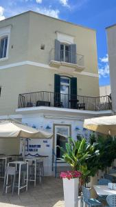 a building with tables and umbrellas in front of it at Appartamento proprio sul mare! in Otranto +37 photos