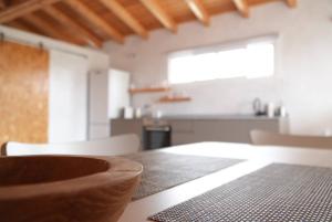 a dining room table with a kitchen in the background at Vitamin Sea Guesthouse in Lajares
