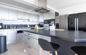 a kitchen with white cabinets and a black counter top at Beautiful Home In Les Issambres in Les Issambres