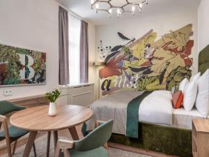 a bedroom with a bed and a table and chairs at The Botanist by Adrez in Prague