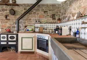 a kitchen with a stone wall and a stove at Historic Villa In The Florence Hills in Borgo San Lorenzo