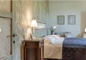 a bedroom with a bed and a table with a lamp at Historic Villa In The Florence Hills in Borgo San Lorenzo