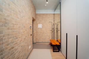 a hallway with a brick wall and a wooden table at Sky Premium Rent in Chişinău