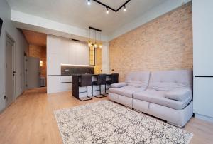 a living room with a couch and a brick wall at Sky Premium Rent in Chişinău +7 photos