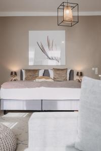 a bedroom with a large bed with a painting on the wall at Boutique Hotel Villa Monika in Westerland (Sylt)
