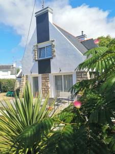 ein Haus mit einem blau-weißen Schornstein und einigen Pflanzen in der Unterkunft Family House Near Mousterlin Beaches in Fouesnant