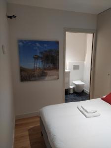 a bedroom with a bed and a painting on the wall at Appartement neuf centre historique in Bordeaux
