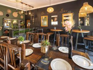 a restaurant with wooden tables and chairs and flowers on a table at Eco Lodge Lephalale in Lephalale