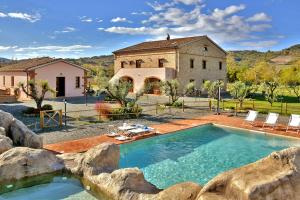 a large swimming pool in front of a building at Podere La Querciola in Guardistallo
