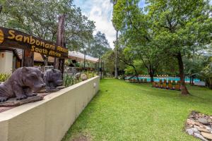 un parc avec deux statues d'animaux sur un mur dans l'établissement Sanbonani Resort Chalets, à Hazyview