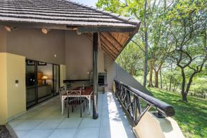 un balcon d'une maison avec une table et des chaises dans l'établissement Sanbonani Resort Chalets, à Hazyview