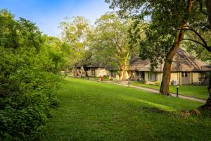 une cour avec une maison et des arbres en arrière-plan dans l'établissement Sanbonani Resort Chalets, à Hazyview