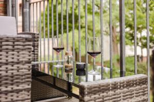 deux verres de vin assis sur une table en verre dans l'établissement Dessaus Motto Appartements! Solo - Pärchen - Familien - Gruppen, à Dessau
