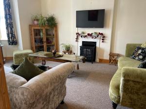 a living room with a couch and a fireplace at St Judes, Mundesley in Mundesley