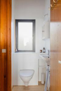 カロンボーにあるLess Is More A Unique 55 Square Meter Experienceのトイレと窓のある白いバスルーム