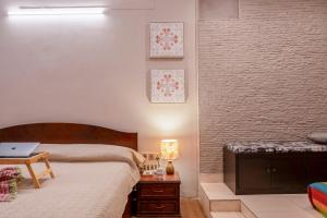 a bedroom with two beds and a table with a laptop at BOHO Bari in Kolkata