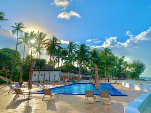 a pool at a resort with chairs and palm trees at Royal Mandarin Hotel & Resort in Pwani Mchangani