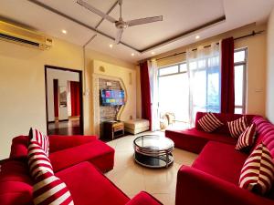 蒙巴萨Magnificent Beachfront Holiday Homes的客厅配有红色沙发和电视