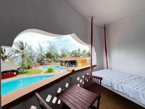 蒙巴萨Magnificent Beachfront Holiday Homes的一间带床且可欣赏泳池景观的房间