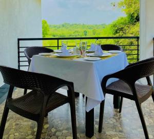 a table with chairs and a white table cloth on it at Samudra Luxe Resort in Habarana