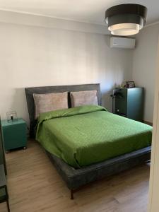 a bedroom with a bed with a green comforter at Penthouse in the historic center in Brindisi