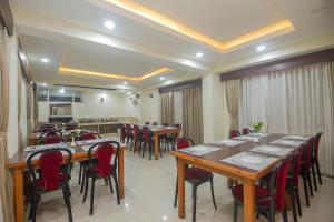 a restaurant with wooden tables and red chairs at Golden Oren Hotels and Spa in Darjeeling