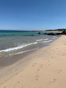 two footprints in the sand on a beach at Penthouse in the historic center in Brindisi