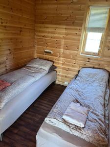 a room with two beds in a wooden cabin at Øse Camping in Gratangen
