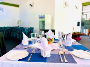 a table with white plates and silverware on top at Samudra Luxe Resort in Habarana +15 photos