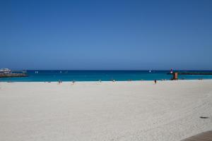 罗萨里奥港Atlantic Loft的一群人在沙滩上与大海