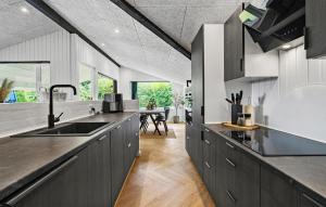 a kitchen with gray cabinets and a dining room at 4 Bedroom Awesome Home In Otterup in Otterup