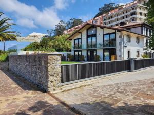 a house with a stone wall next to a building at Maison Laida in Ibarrangelu