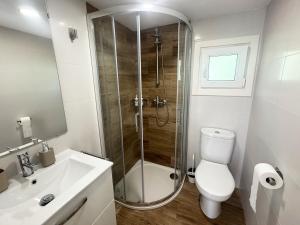 a bathroom with a shower and a toilet and a sink at As Cortiñas, casa vacacional completa en Laxe 